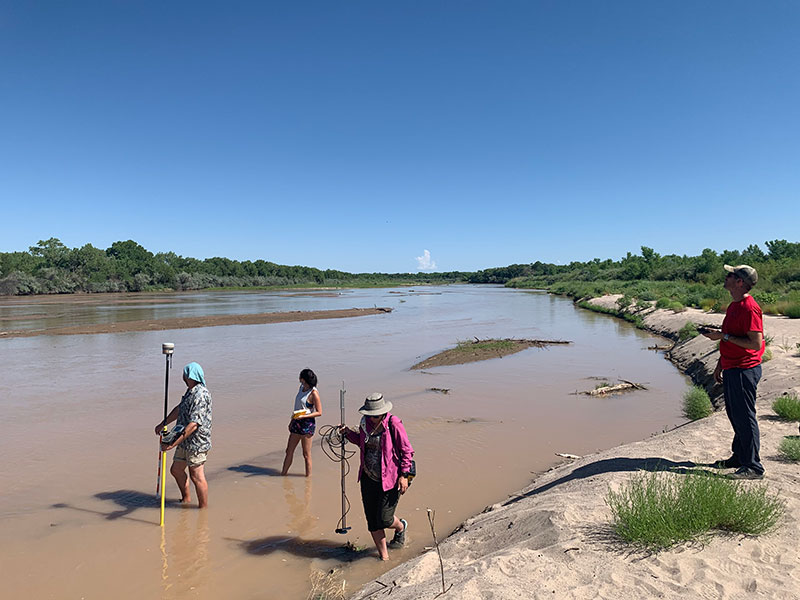 Researchers wading  in the Rio Grande